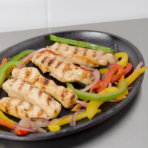 Grilled chicken and peppers on a Lodge oval cast iron fajita skillet.
