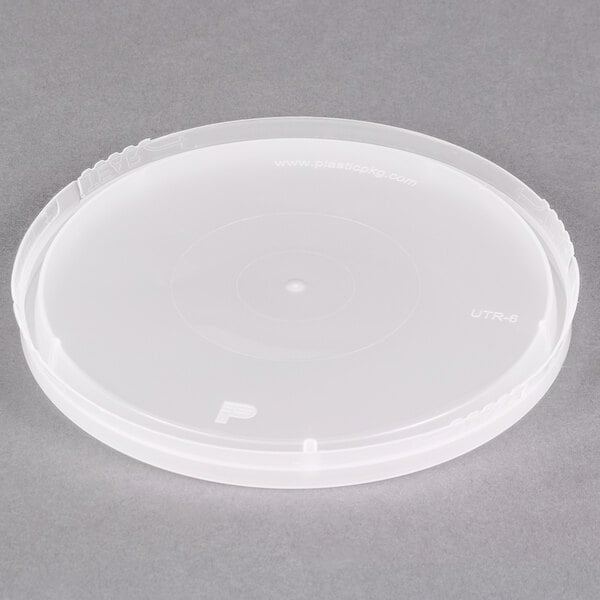 A translucent plastic lid with a circle on top for round deli containers.