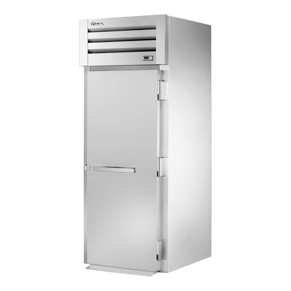 A silver True Spec Series roll-in refrigerator with a white rectangular door.