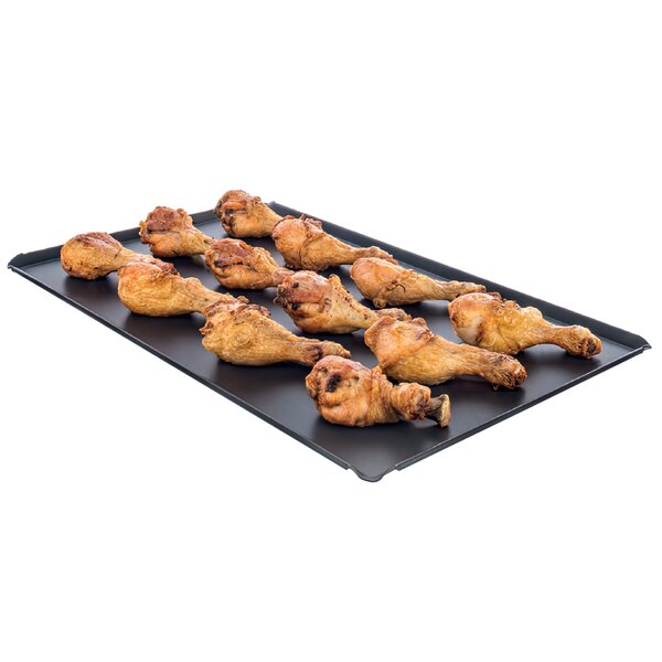 A Rational roasting tray of fried chicken legs.