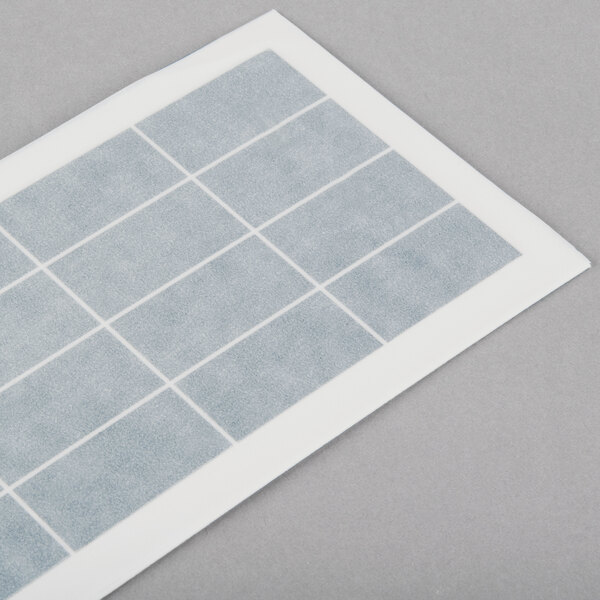 A white and grey rectangular Curtron insect trap glue board with squares on it.