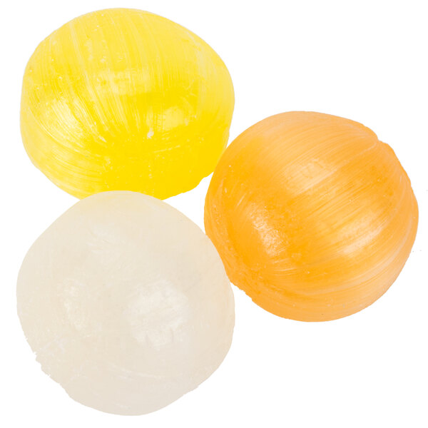 A close up of a group of round yellow and white candies.