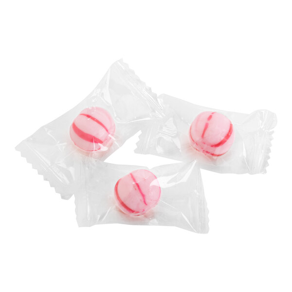 Three individually wrapped pink and white striped hard candies are shown on a white background.