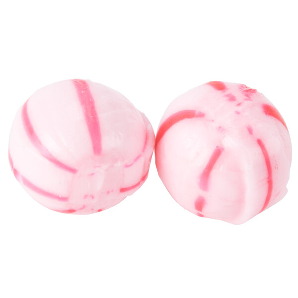 Two pink and white hard peppermint balls.