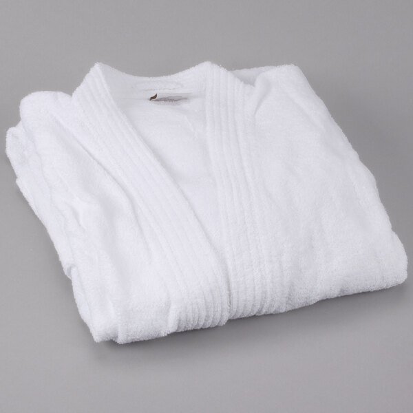 A pack of white Oxford Terry bathrobes folded on a gray surface.