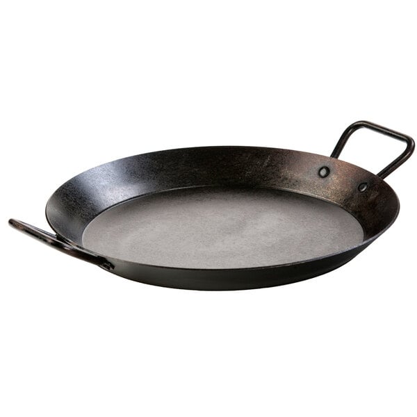A Lodge carbon steel paella pan with loop handles.