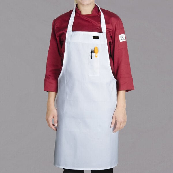 A woman wearing a white Chef Revival bib apron.