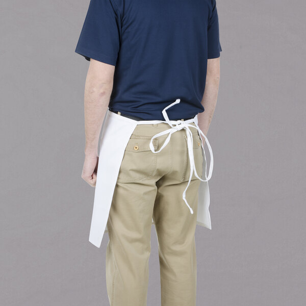 A man wearing a Chef Revival white bistro apron with 2 pockets.