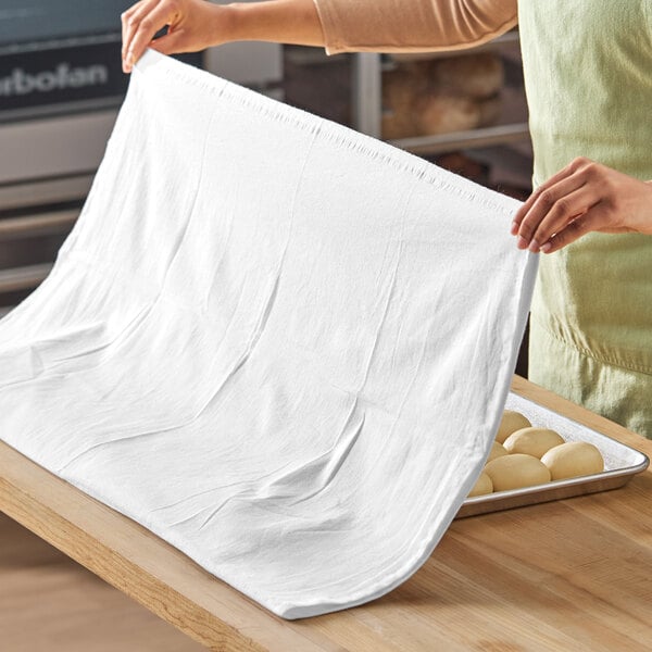 A large white 100% cotton flour sack towel being used in a kitchen setting.