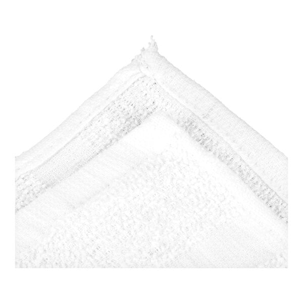 A close-up view of the corner of a white, textured terry cloth fabric with visible stitching.