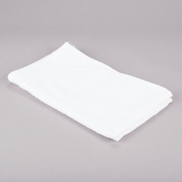 A white Chef Revival bar towel on a gray surface.