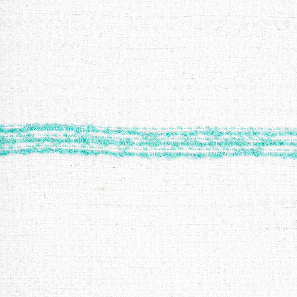 A close-up view of a white fabric with a horizontal green stitched stripe.