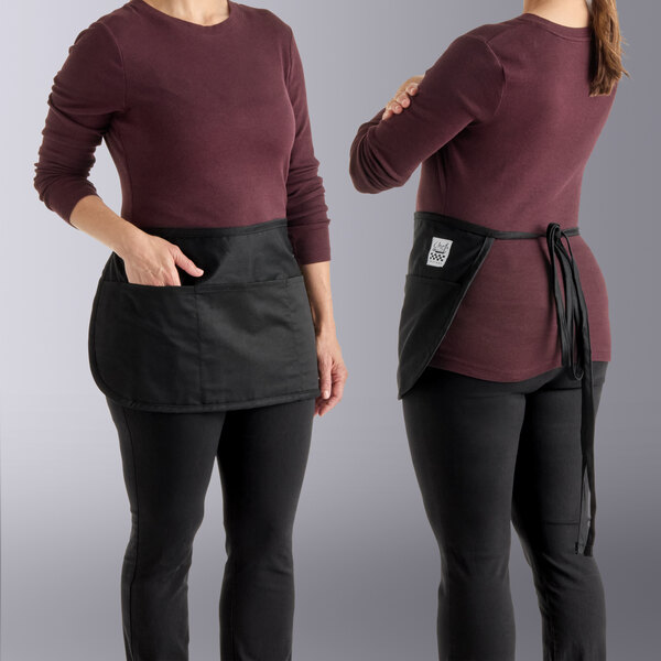 Two women wearing Chef Revival black waist aprons standing on a deli counter.