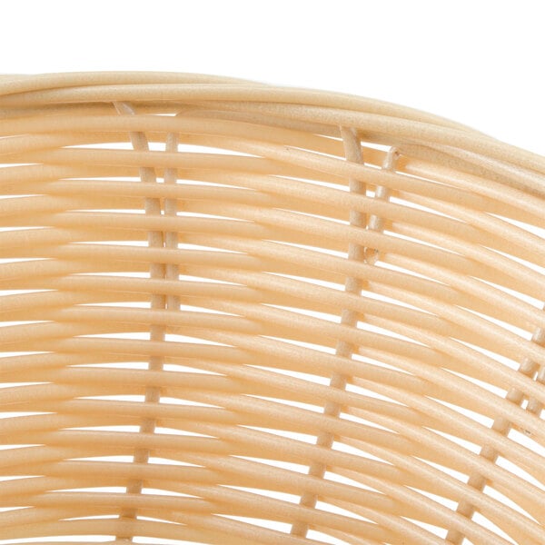 A close up of a Thunder Group round rattan bread basket.
