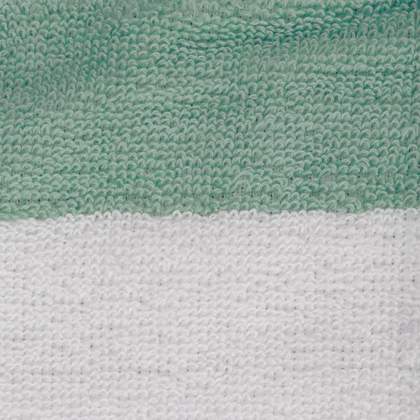 A close up of a green and white striped Oxford cabana pool towel.
