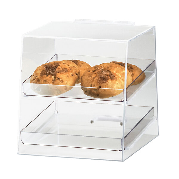 A clear plastic display shelf in a bakery display case holding food.