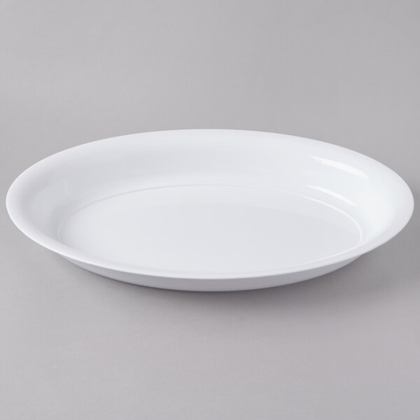 A Fineline white plastic deep oval bowl on a gray surface.