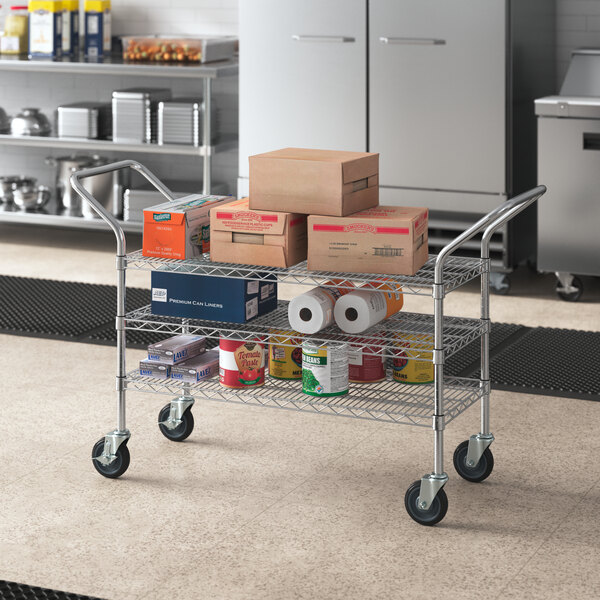 A Regency chrome utility cart with boxes stacked on it.