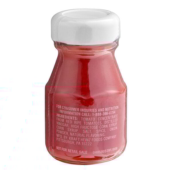 A close-up of a Heinz Ketchup personal glass bottle.