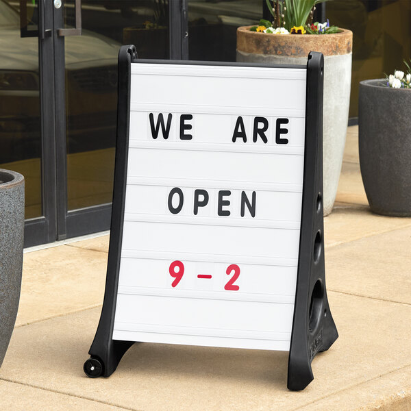 A white Aarco Replacement Roll sign on a sidewalk.