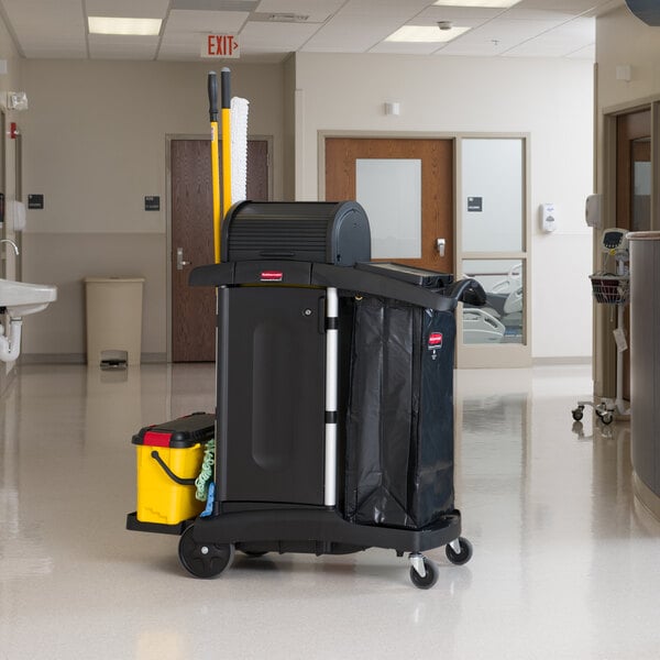 A Rubbermaid Executive High Security Janitor Cart with a locking hood and cabinets, equipped with cleaning supplies and a waste bag.