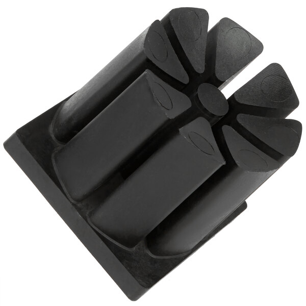 A black plastic push block with four holes.