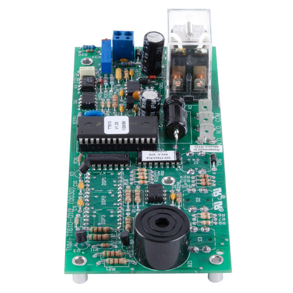 A green circuit board with a black round object and a chip.