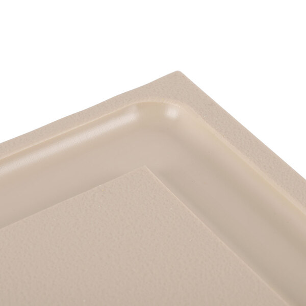 A beige polyethylene carving board with a small hole in it.
