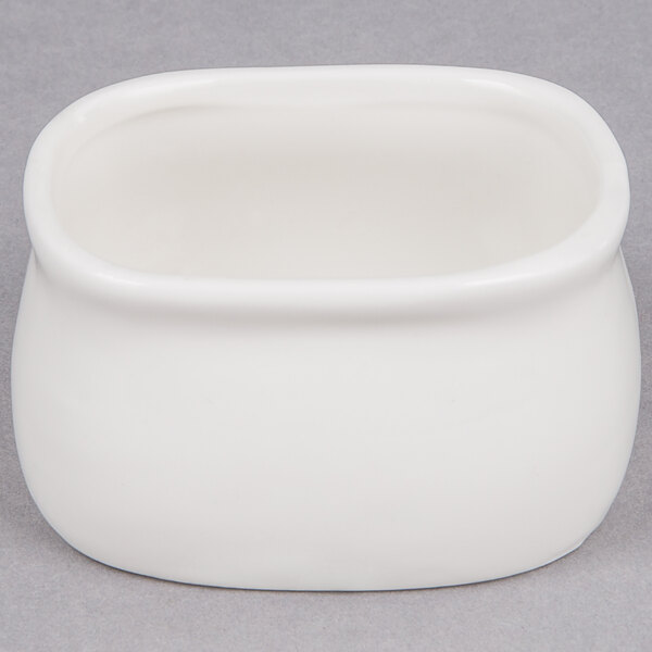 An American Metalcraft white porcelain bowl with a lid on a gray surface.