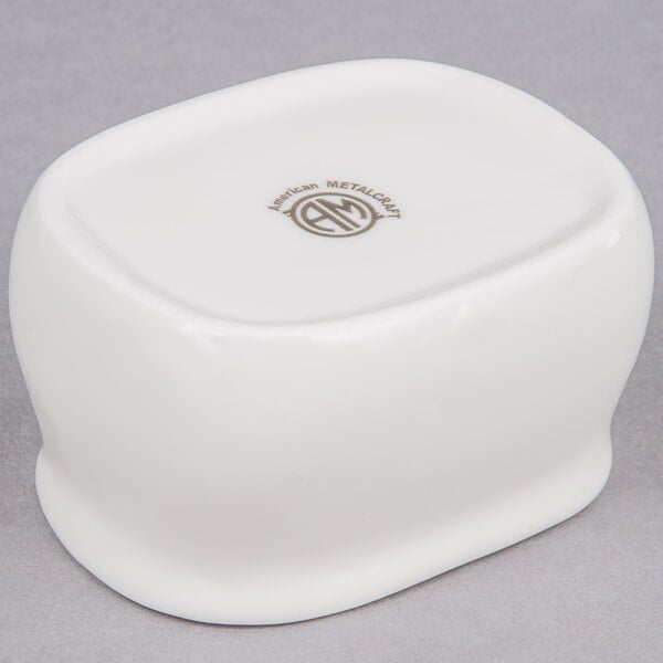 A white rectangular porcelain sugar packet holder with a logo on it.