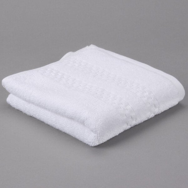 A white folded Oxford Viceroy hand towel on a gray surface.