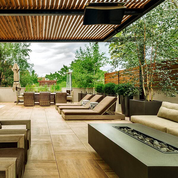 A patio with a fire pit and chairs with a Bromic Heating Platinum Smart-Heat Natural Gas Outdoor Patio Heater.