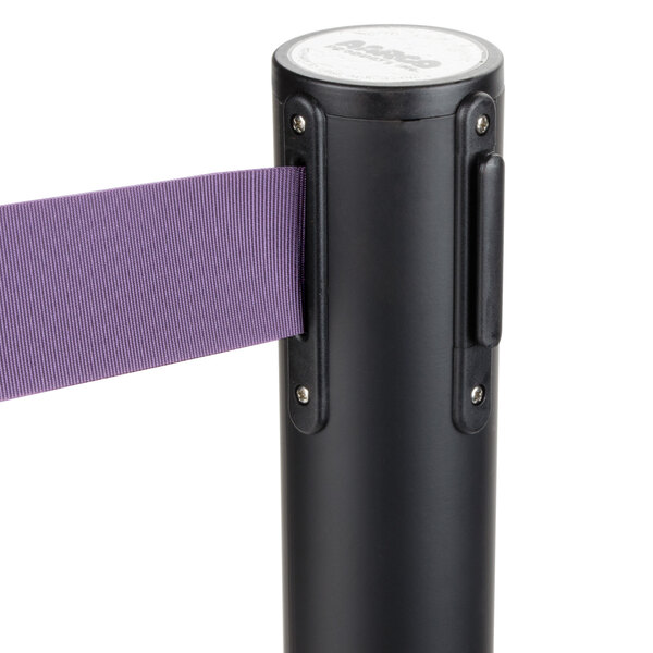 A black Aarco crowd control stanchion with purple retractable tape.