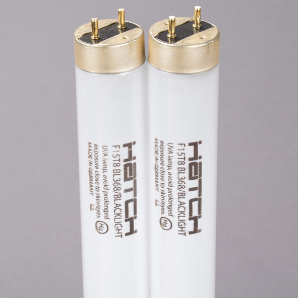 Two white Curtron UV tubes with gold caps.