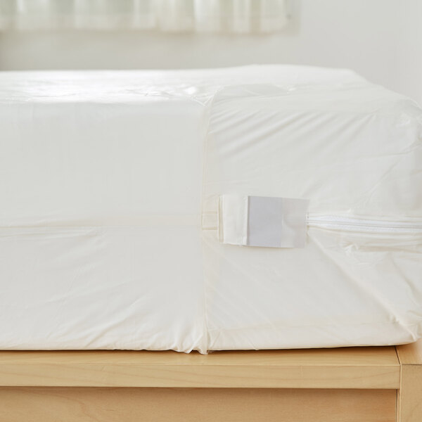 A white Bargoose vinyl mattress cover on a bed with a white sheet.