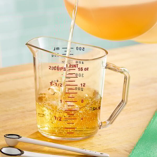 A Cambro clear polycarbonate measuring cup filled with liquid.