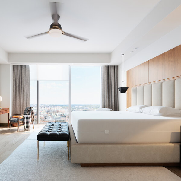 A white bed with a Bargoose Hybrid zippered mattress encasement on it.