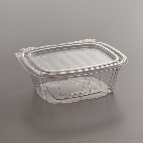A clear Dart deli container with a flat lid on a table.