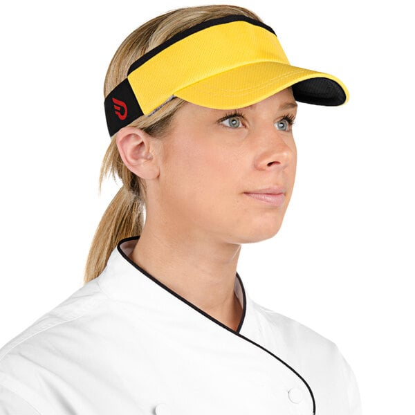 A woman in a chef's uniform wearing a yellow Headsweats visor.