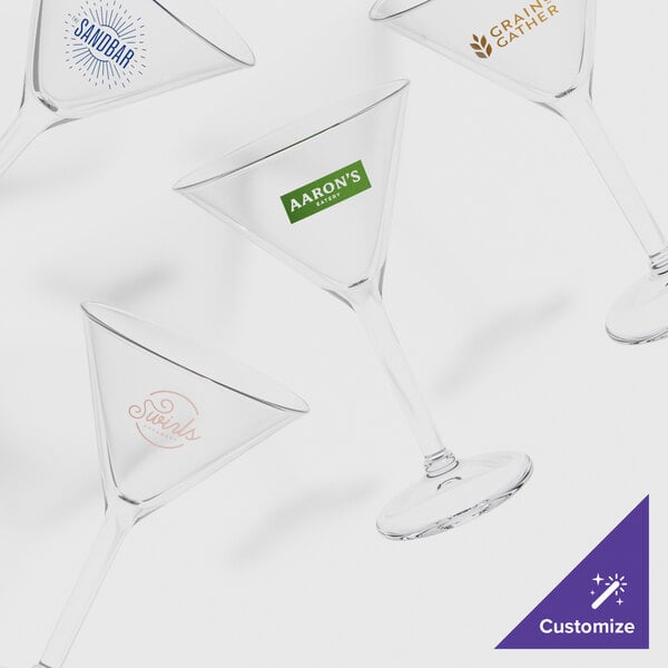 A group of clear GET Customizable martini glasses with a logo on one of them.