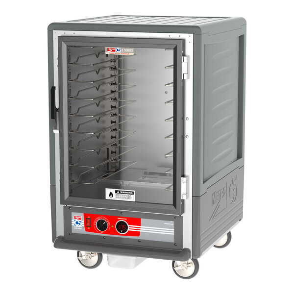 A large grey Metro heated holding cabinet with clear glass doors and wire shelves.