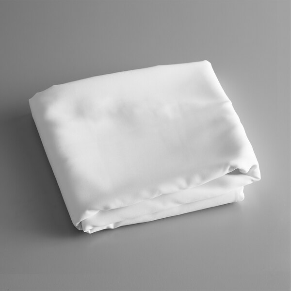 A folded white table cover on a gray surface.