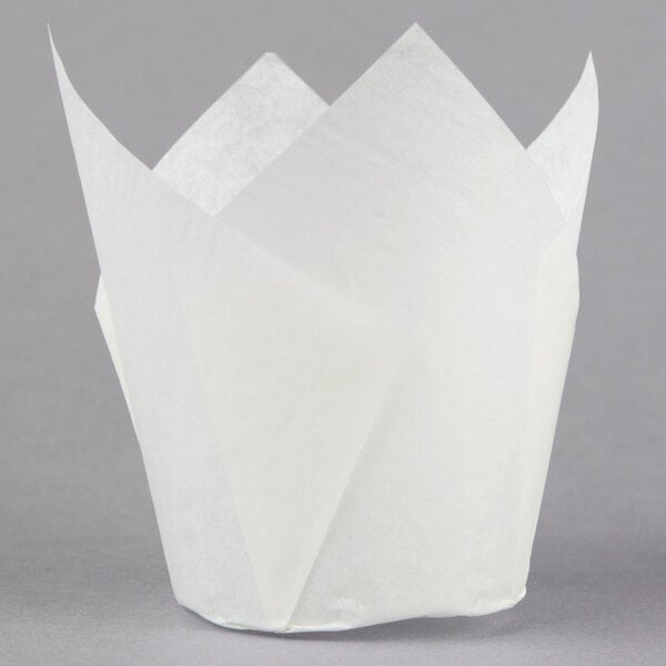A close-up of a white Hoffmaster tulip baking cup with a folded edge.