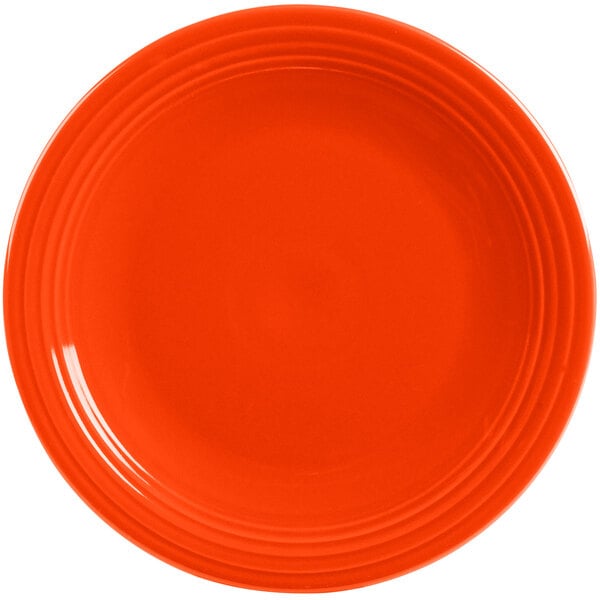 An orange Fiesta® Dinnerware chop plate with a rim.