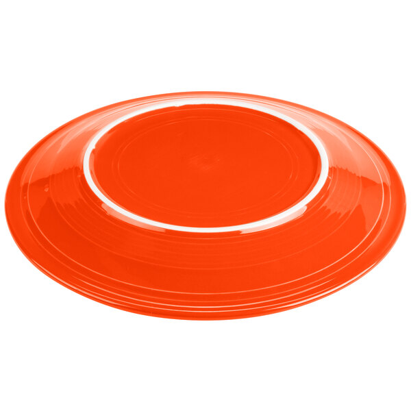 A close-up of a Fiesta® Poppy China round chop plate with a white border.