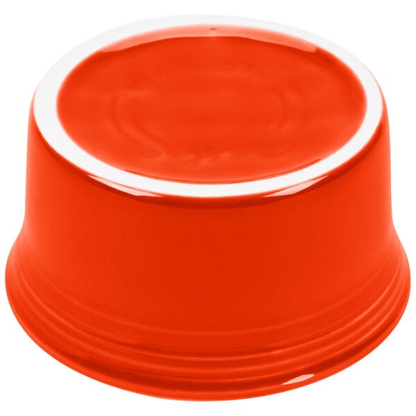 A Fiesta poppy china ramekin with a white rim containing red liquid.