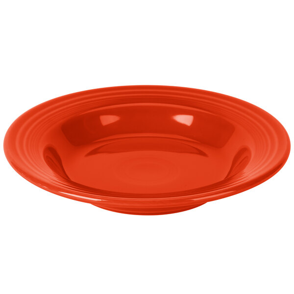 A red Fiesta China rim soup bowl with a white interior and background.