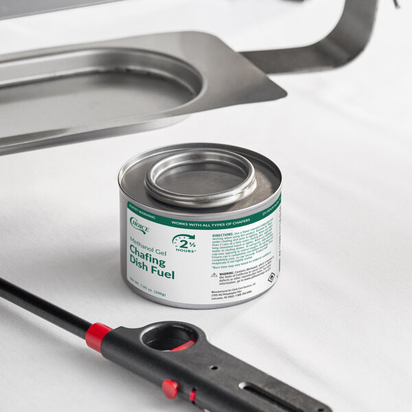 A can of Choice 2.5 hour methanol gel chafing dish fuel placed next to a lighter and a chafing dish stand.