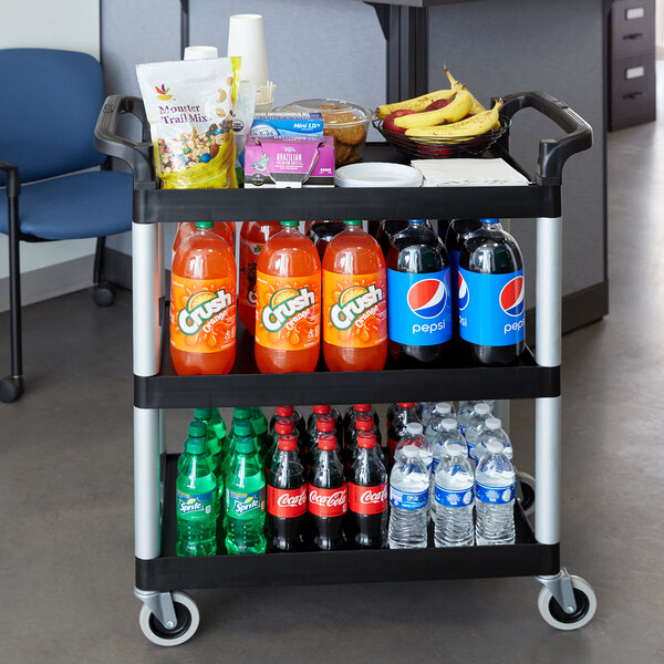 A black Cambro utility cart with food and drinks on it.