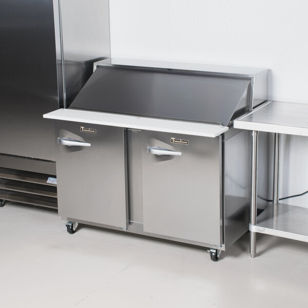 A Traulsen stainless steel refrigerator with silver doors on a counter.